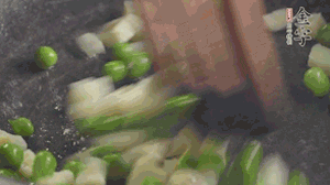 鍋中油7成熱時(shí)，入青豆、筍丁翻炒，然后加糯米飯加鹽均勻翻炒。