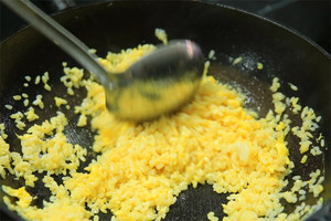 大火加熱炒鍋，再入油，燒到四至五成熱時倒入雞蛋液，在未凝結(jié)之前，加米飯煸炒，不停翻炒并用鍋鏟將成塊的米飯碾開、撥散。