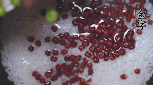 將炒好的食材和大米、紅豆一起放進(jìn)電飯鍋煮。