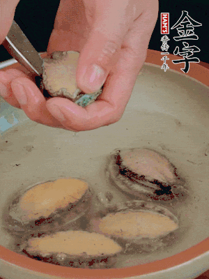鮑魚加鹽、清水浸泡，用勺子挖出鮑魚肉。