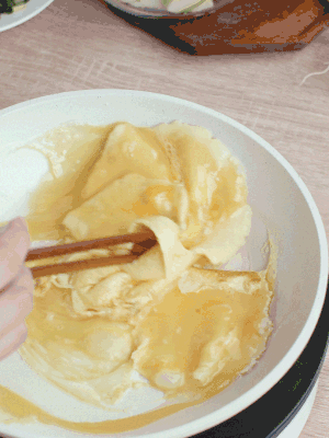 油6成熱時(shí)，下雞蛋液，邊緣凝固時(shí)翻拌成塊狀。