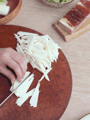 茭白切細(xì)絲，鹽水中浸泡防止氧化。