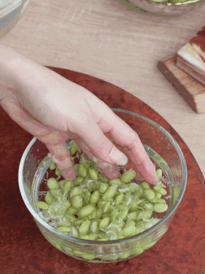 青豆剝殼，搓去外衣。