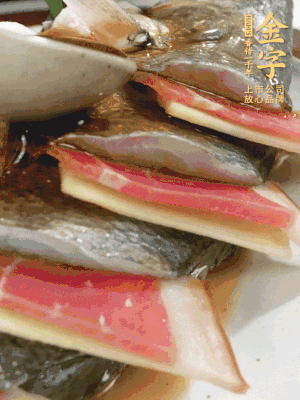 魚肚中塞蔥結(jié)、火腿片，魚身上碼放姜片、火腿片，倒入混合的料汁。