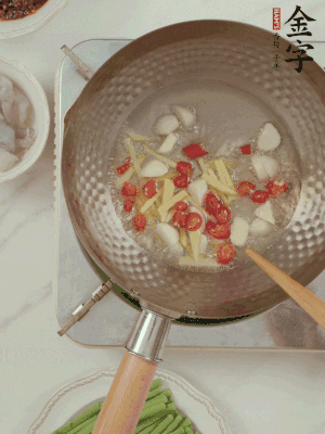 油7成熱時，下大蒜粒、姜絲、小米辣煸香。