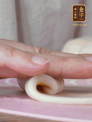 做面劑 油皮按扁，中間包入一個油酥，邊緣收緊捏死。包好的面劑按扁，用搟面杖搟壓成橢圓形。從底部向上卷成筒狀，用保鮮膜蓋好松弛15分鐘，再把筒狀縱向搟壓成長條狀。再卷一次，松弛20分鐘