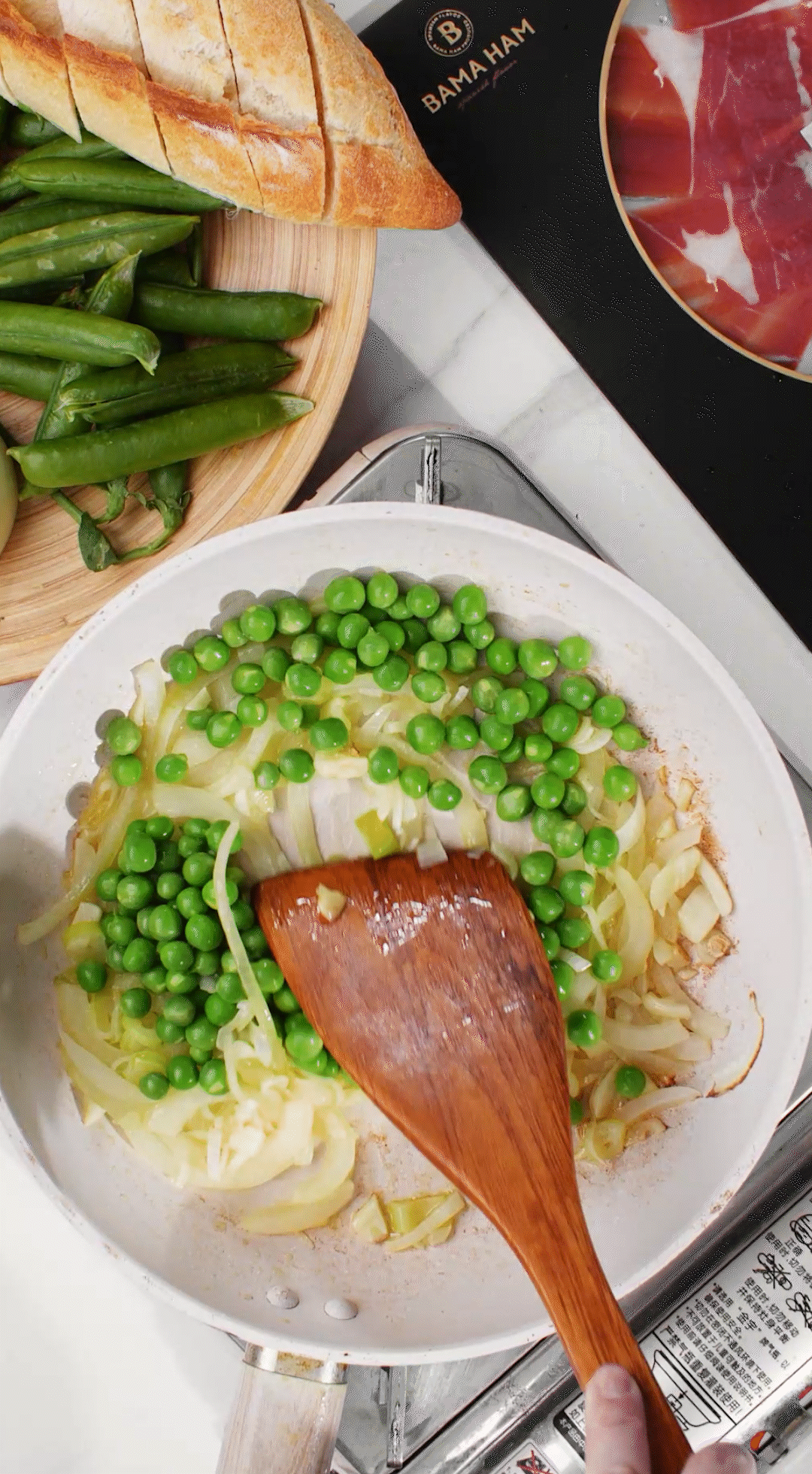 鍋中放入黃油融化，加入洋蔥絲、大蔥蔥白絲、蒜末翻炒變軟出香味。加入剛剛汆燙冰鎮(zhèn)后的豌豆，取出一點(diǎn)點(diǎn)待會(huì)擺盤裝飾用。加一點(diǎn)鹽 (和黑胡椒) 調(diào)味。