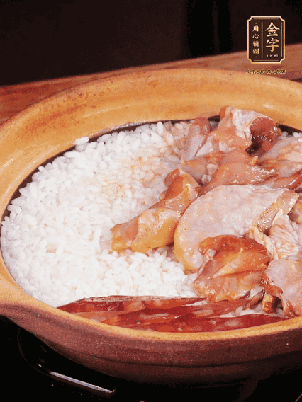 煮到椰子水微微收干轉(zhuǎn)小火，快速均勻鋪上雞肉、金字香腸