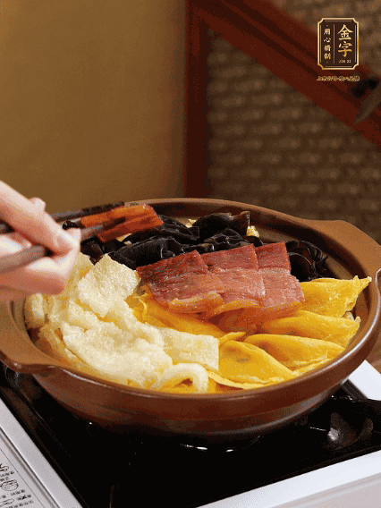 砂鍋底部鋪上娃娃菜，依次擺上肉皮、蛋餃、黑木耳、火腿